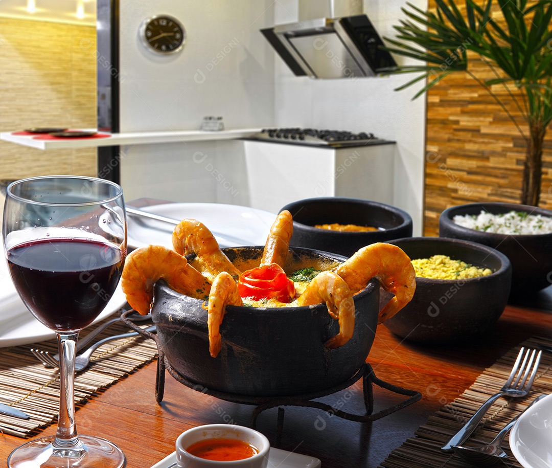 Moqueca de camarão com taça de vinho tinto
