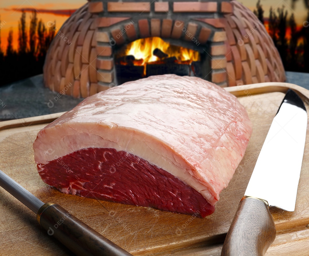 Picanha sobre tábua de madeira com facas