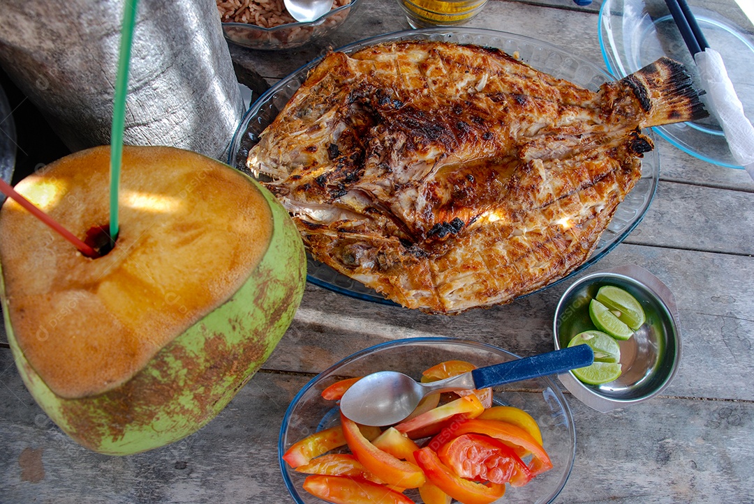 Peixe assado na grelha com tomates e água de coco