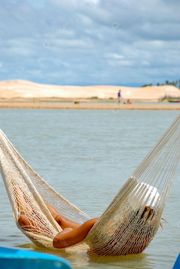 Uma turista deitada na rede de uma praia