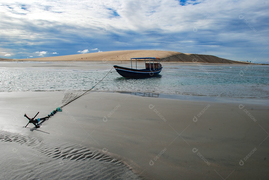 Barco ancorado em uma praia virgem escondida atrás das dunas da costa oeste de Jijoca