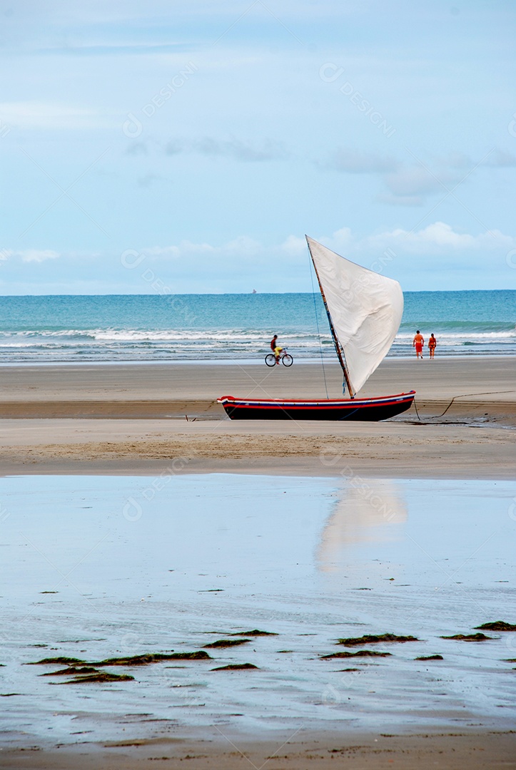 Barco pequeno com velas ancorado em uma praia