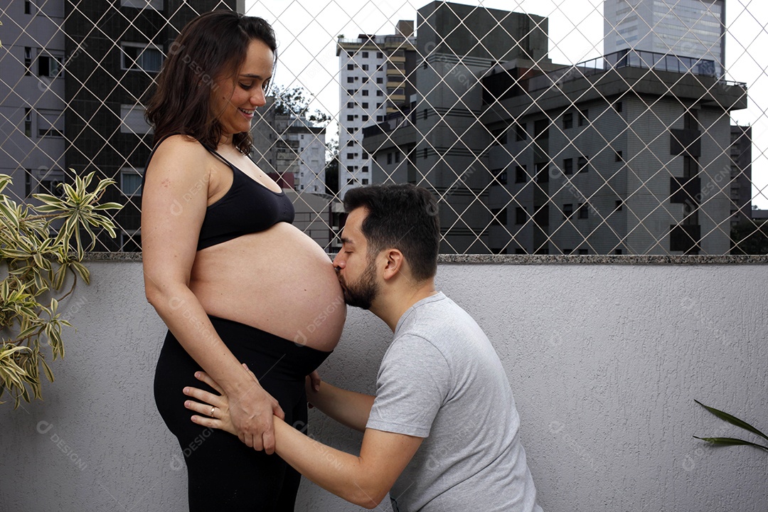 Homem beijando barriga da sua mulher