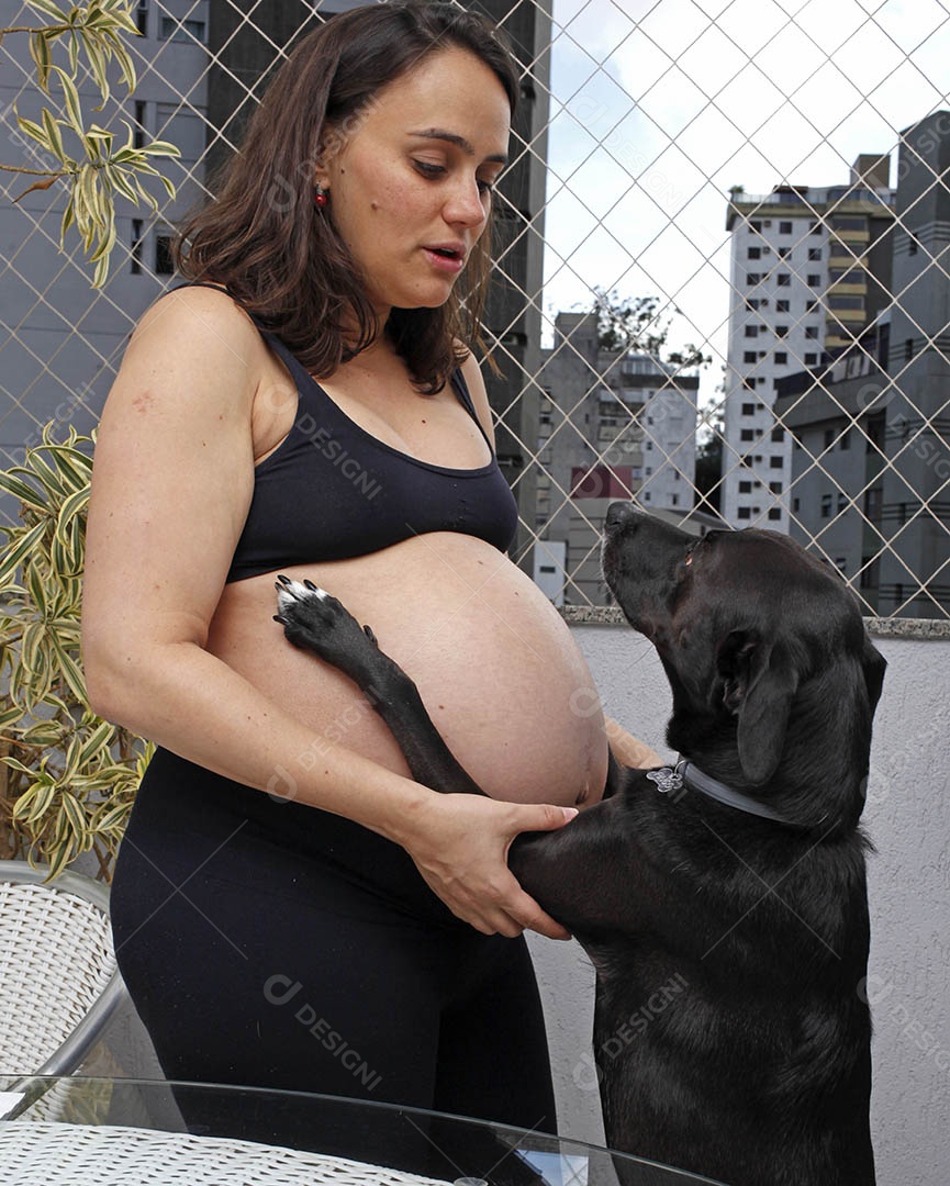 Linda mulher grávida brincando com seu pet