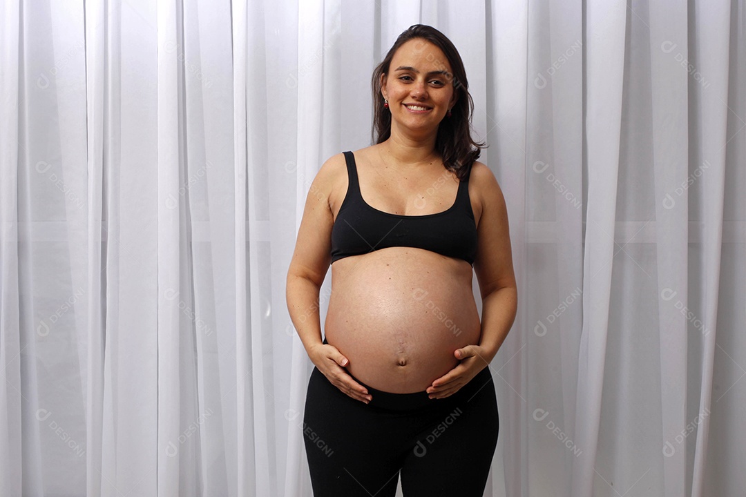 Mulher grávida com mãos na barriga