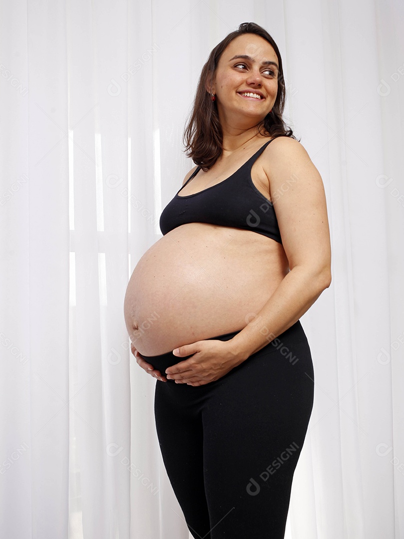 Linda mulher feliz com mãos na barriga