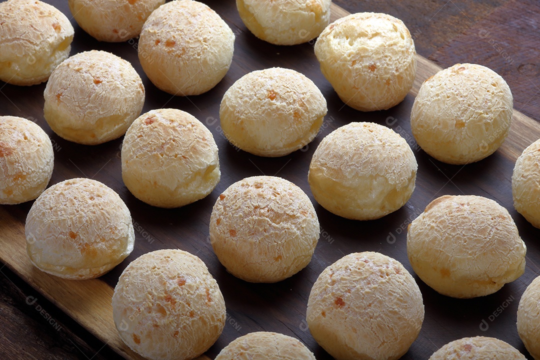 Pães de queijo sobre uma tábua de madeira