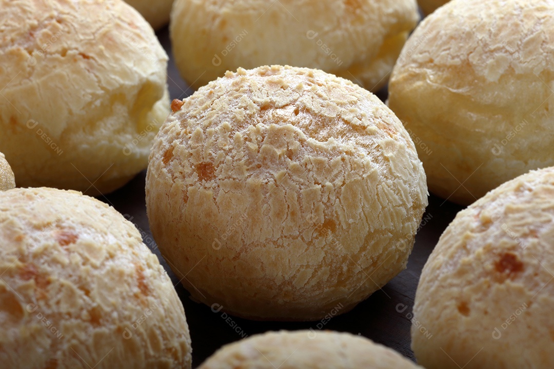 Pães de queijo sobre uma tábua de madeira