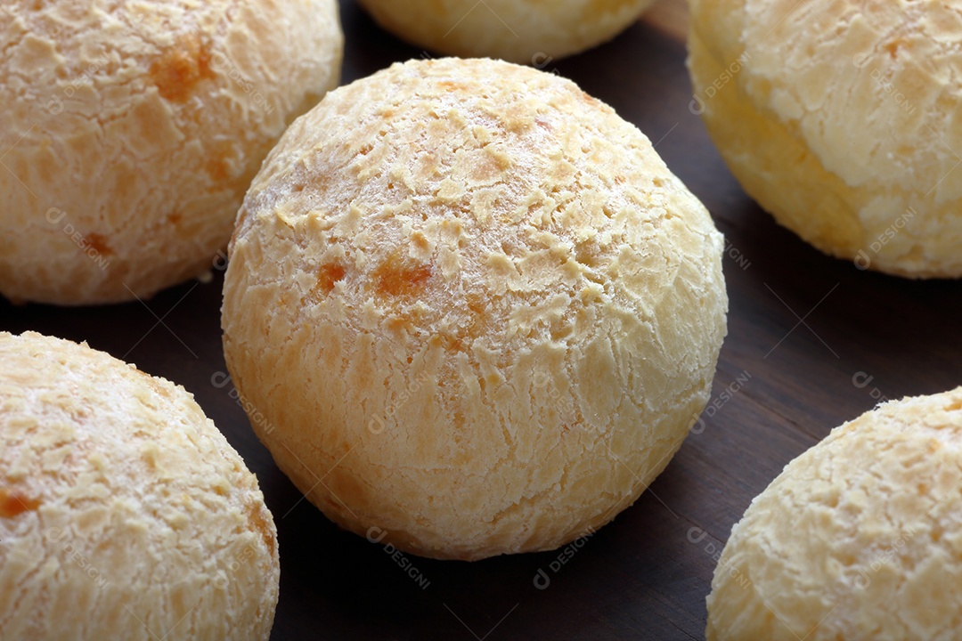 Pães de queijo sobre uma tábua de madeira