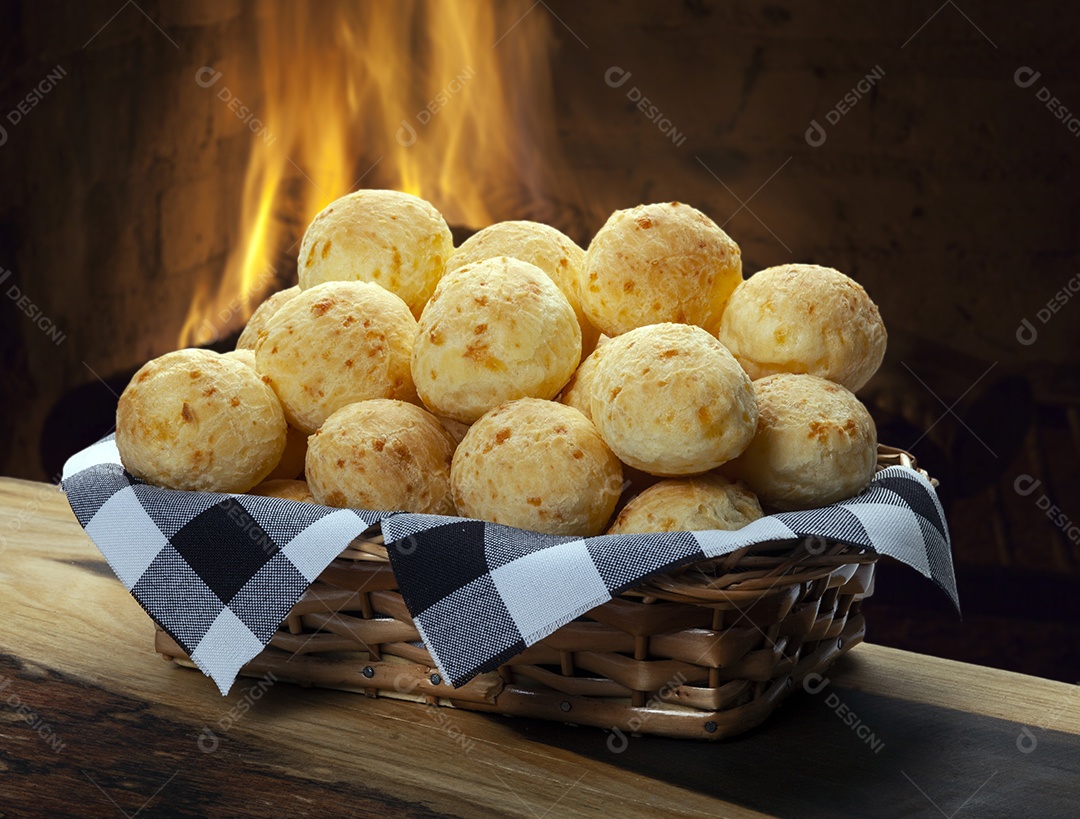 Cesta com pães de queijo delicioso sobre uma mesa de madeira