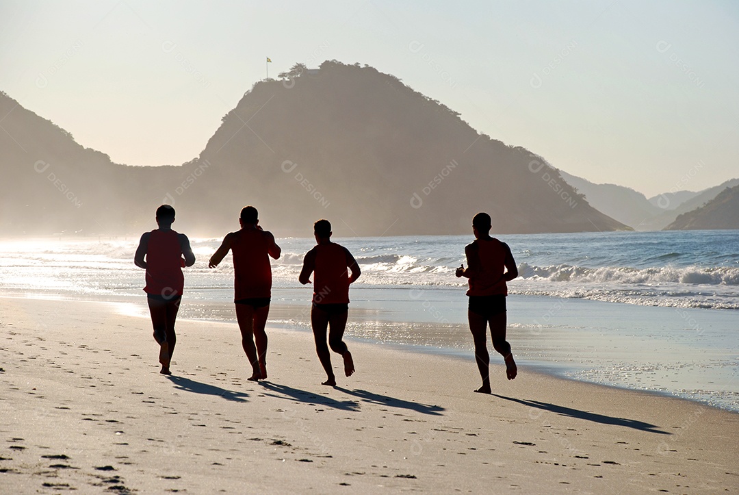 Pessoas correndo na areia da praia