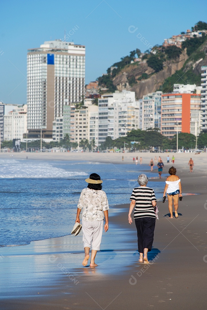 Pessoas caminhando em areia de praia copacabana