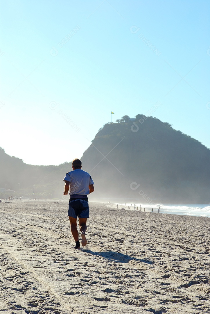Homem correndo na areia da praia de copacabana