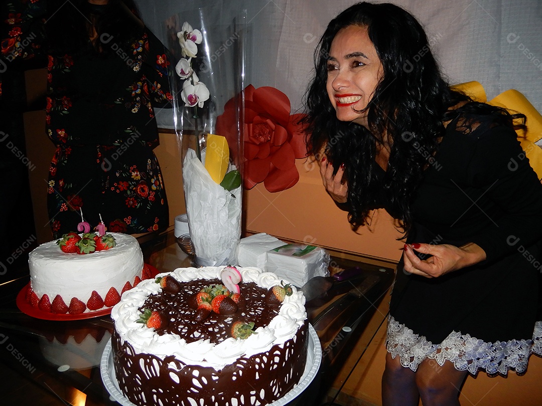 Mulher comemorando aniversário com bolo de chocolate e morangos