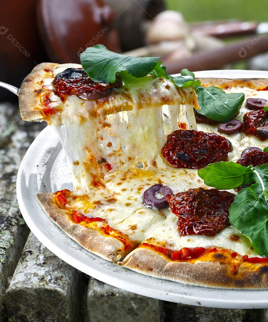 Pizza com tomate seco rúcula e mussarela em pizzaria