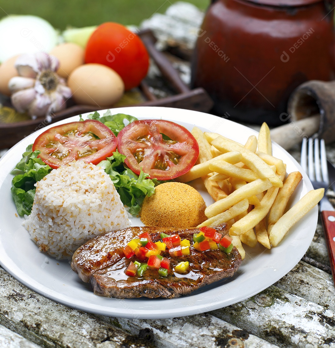 Arroz com batata e carne em um prato sobre mesa de madeira
