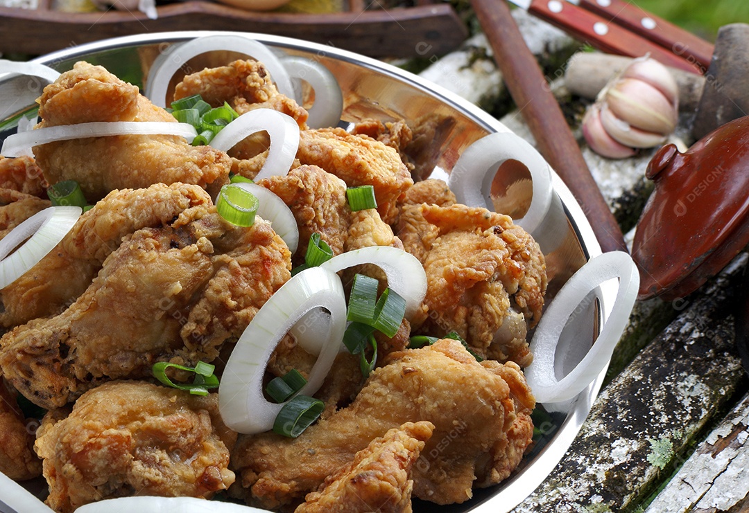 Carne de frango acebolada em tijela sobre mesa de madeira