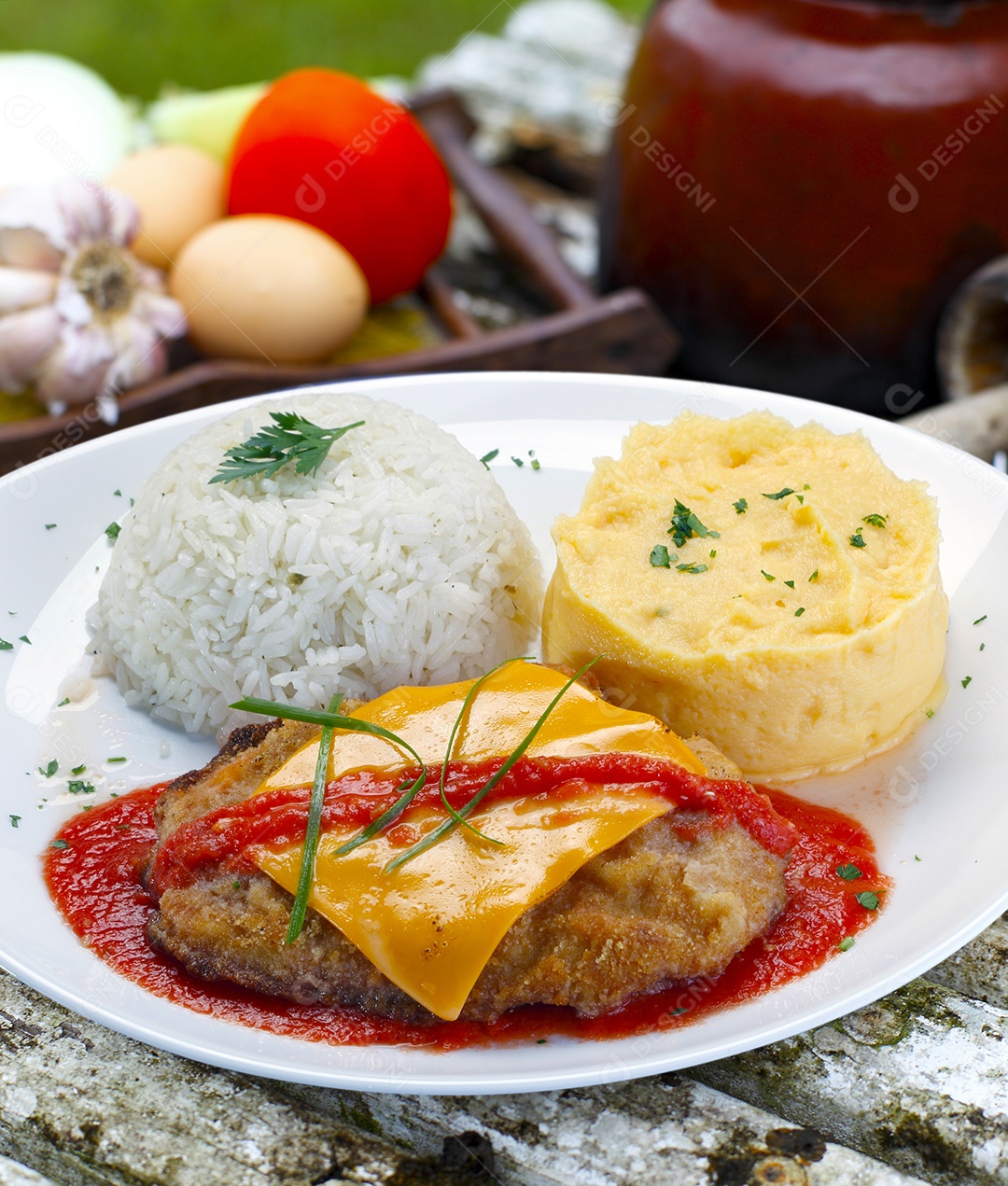 O bife à parmegiana com batata e arroz em um prato sobre fundo isolado