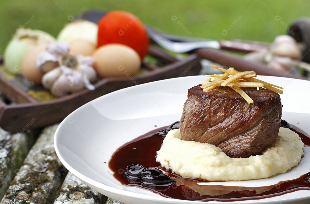 Filé mignon ao molho de vinho tinto em tijela sobre fundo desfocado
