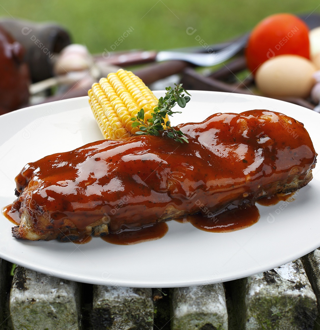 Costela assada com molho barbecue em um prato sobre fundo desfocado