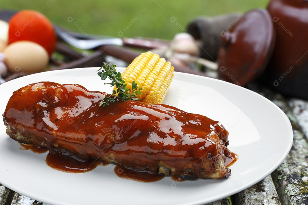 Costela assada com molho barbecue em um prato sobre fundo desfocado