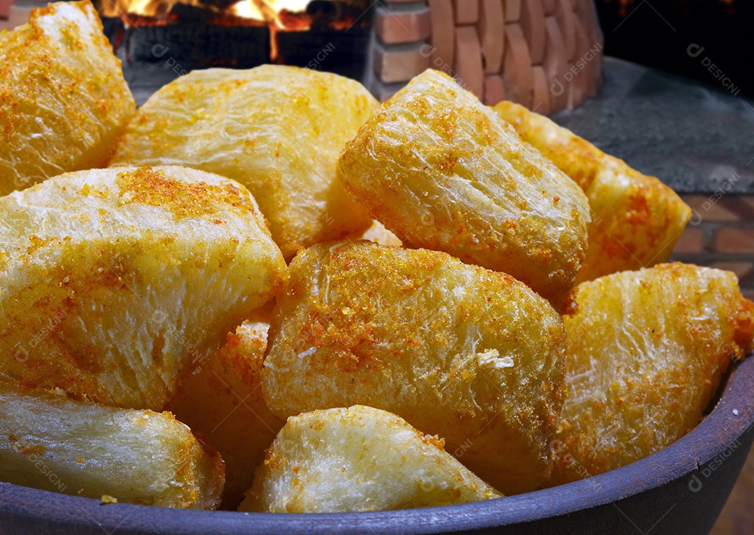 Mandioca frita em tijela sobre mesa de madeira