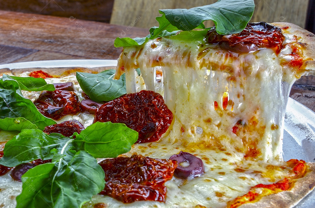 Pizza com tomate seco rúcula e mussarela em pizzaria