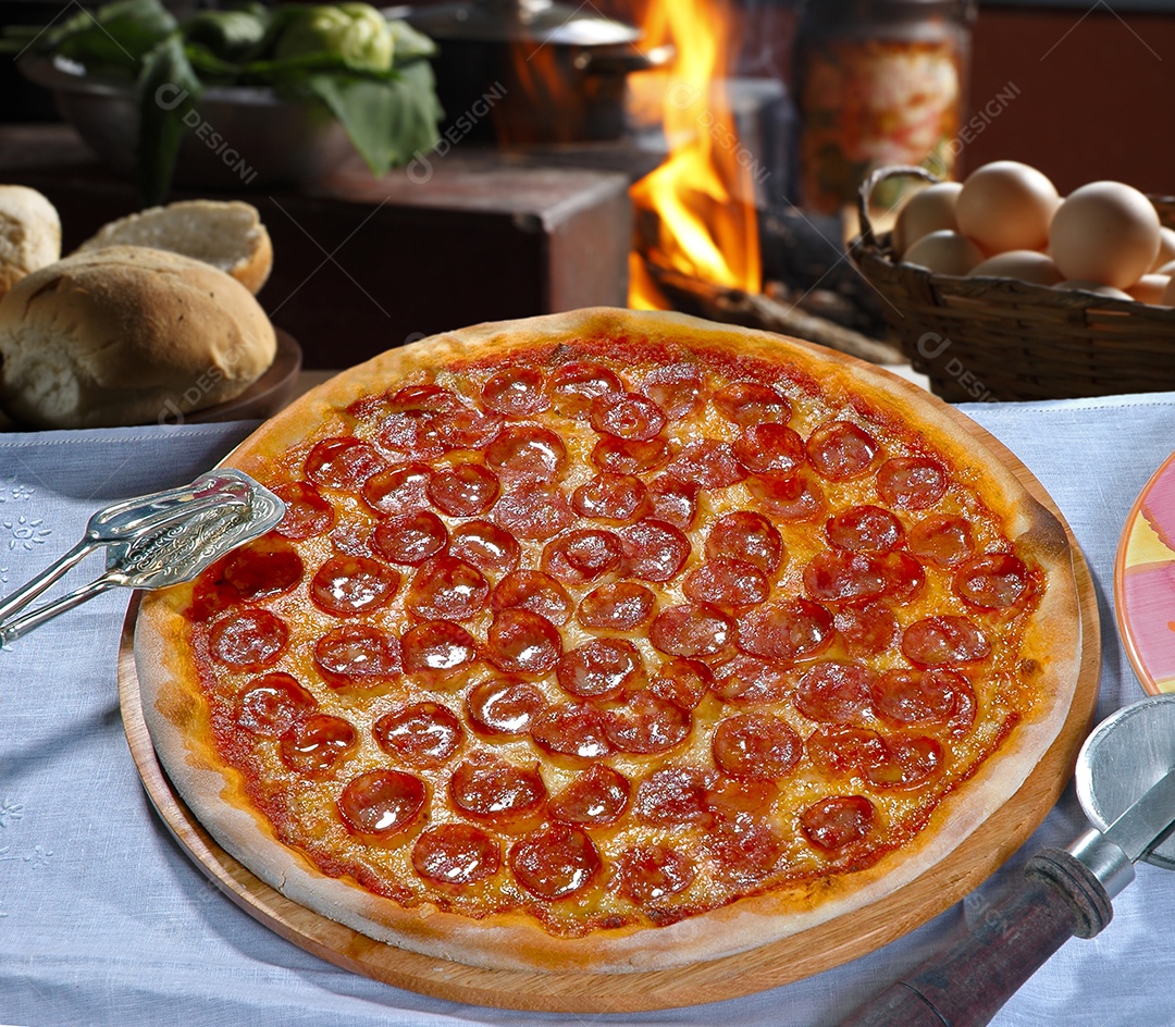 Pizza de calabresa com azeite sobre tábua de madeira