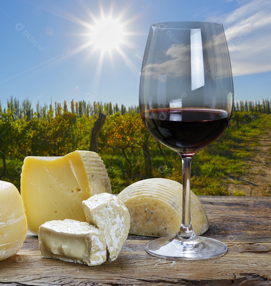 Queijos sobre uma táabua de madeira com taça de vinho