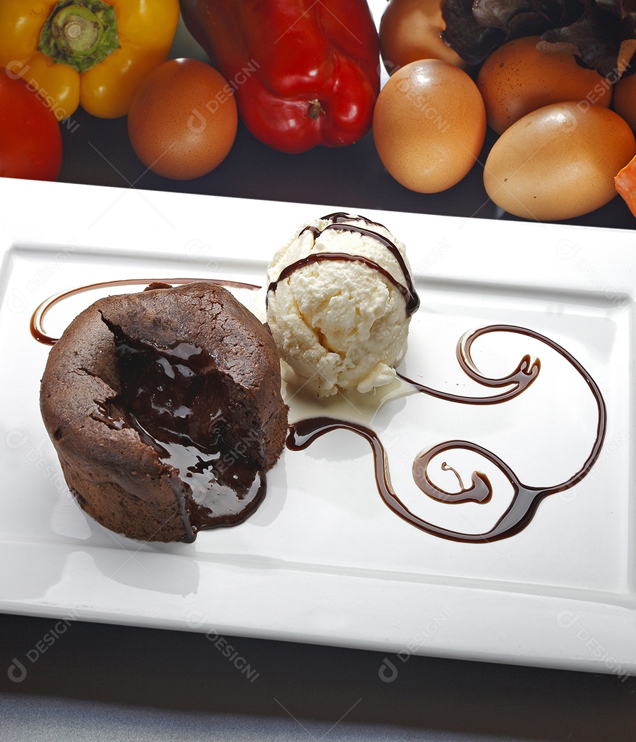 Bolo de chocolate com bola de sorvete ao lado e cobertura