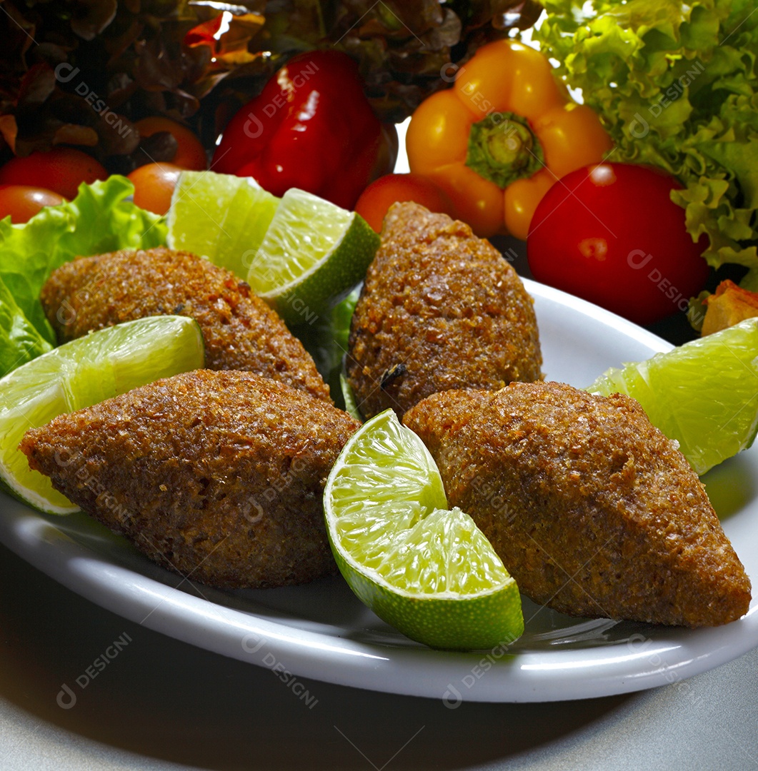 Quibes fritos em uma travessa com bandas de limãos