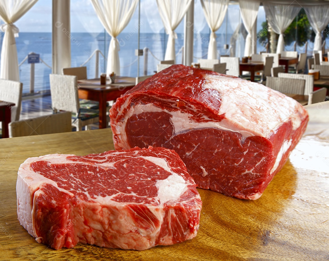 Peça de carne crua sobre fundo de madeira