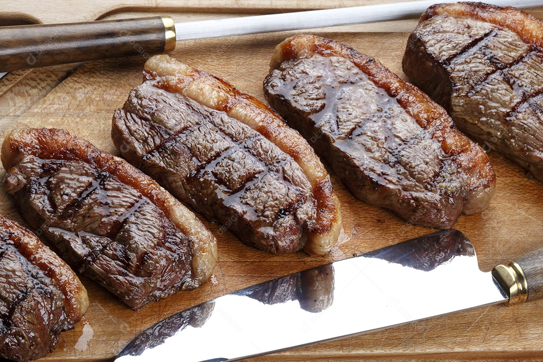 Picanha fatiada assada sobre tábua de madeira