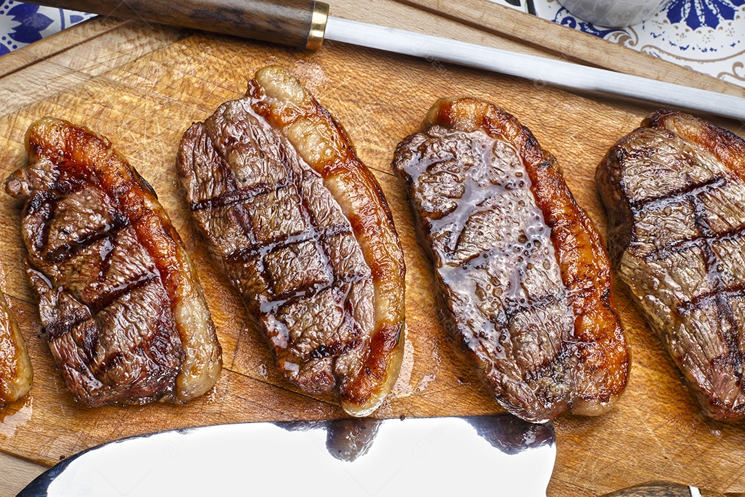 Picanha deliciosa mal passada e suculenta sobre tábua de madeira