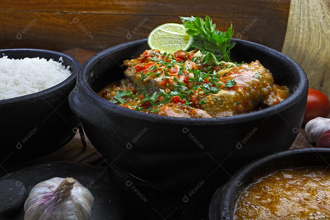 Panela com tradicional moqueca de peixe e arroz