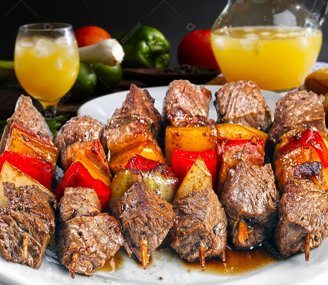 Espetinhos de carne com legumes sobre um prato branco