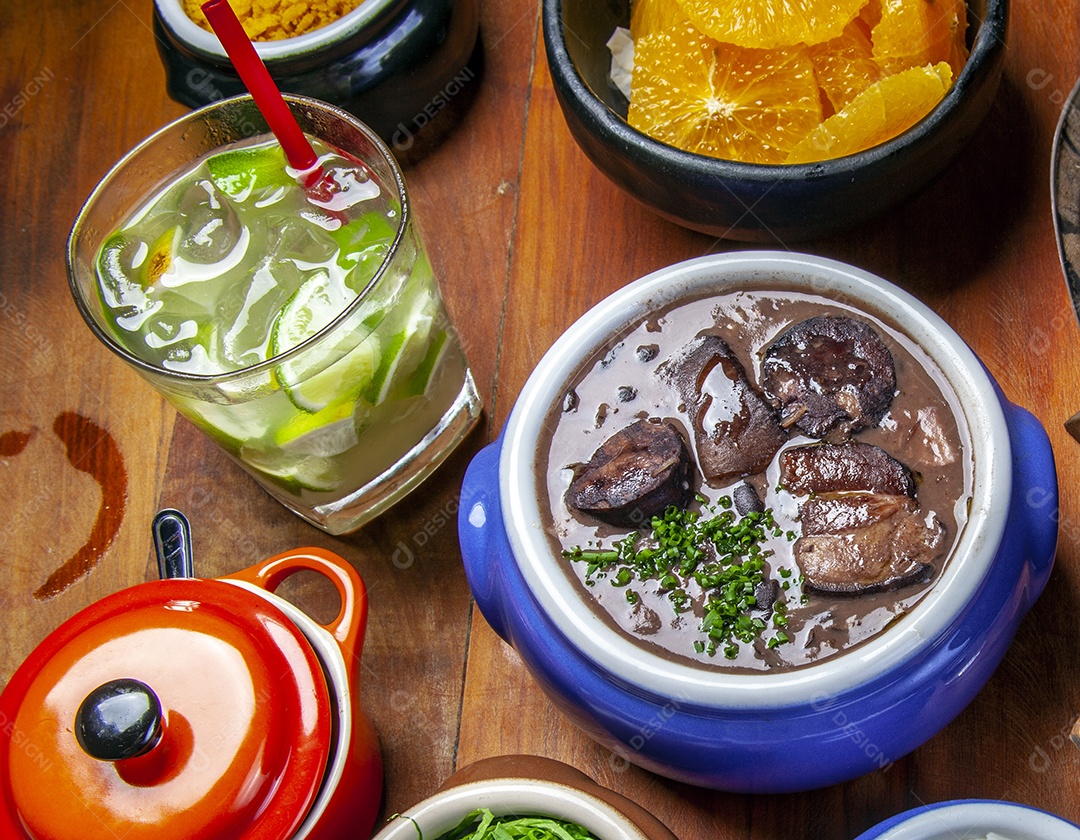 Caipirinha com feijoada sobre mesa de madeira