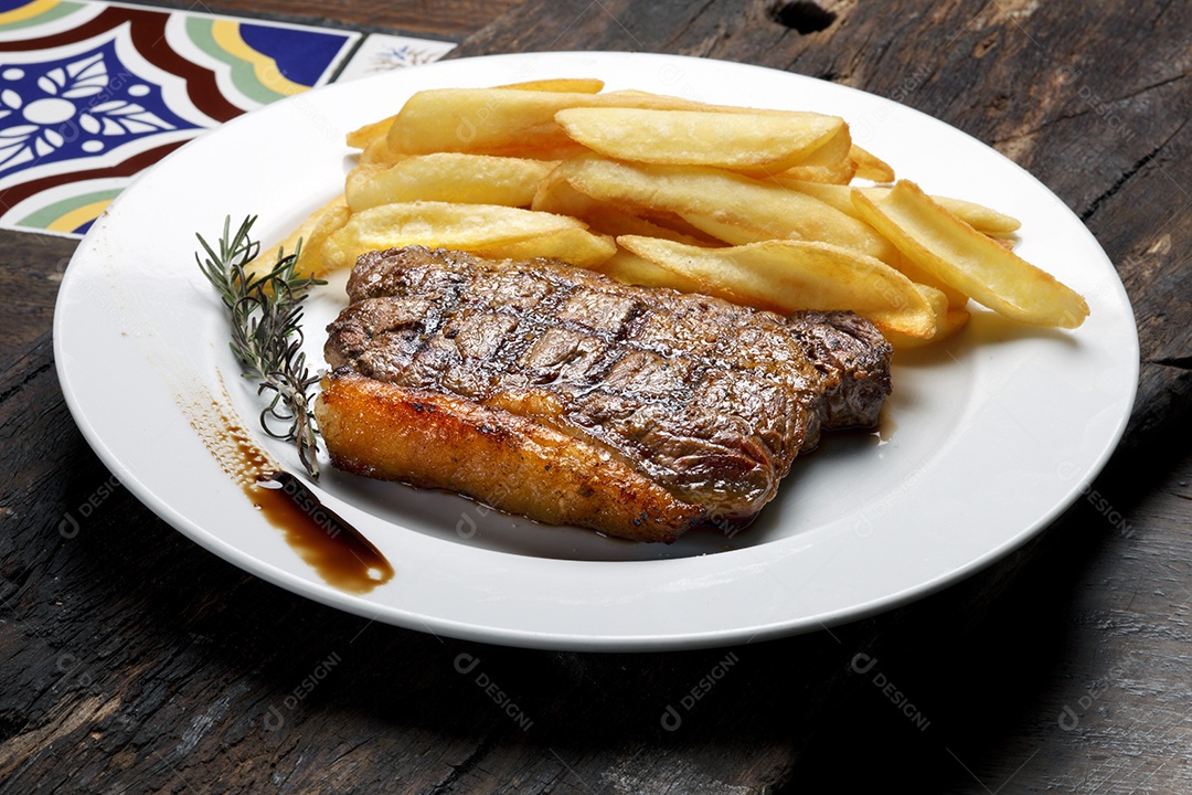 Picanha assada com batatas fritas em um prato branco