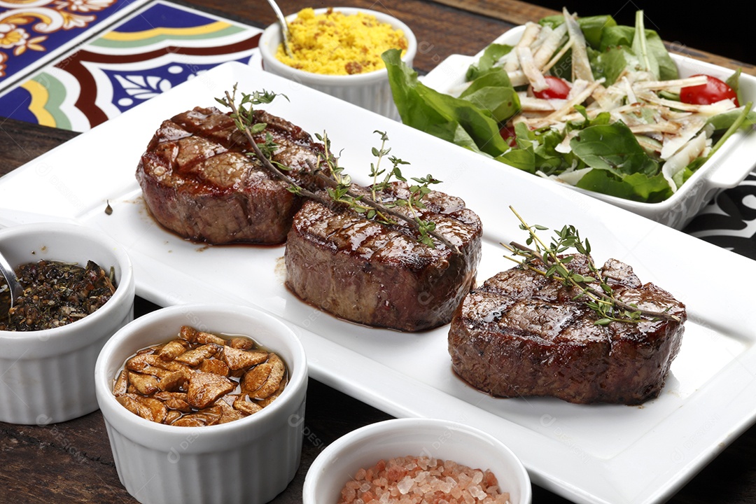 Três bifes assados ​​na grelha