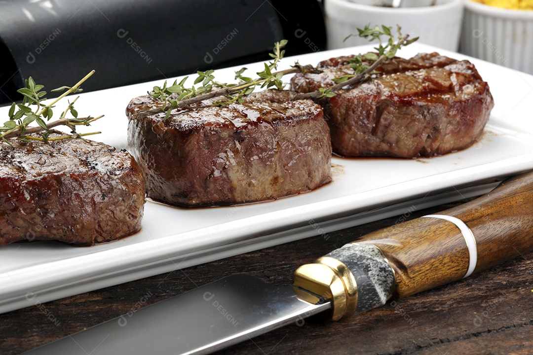 Três bifes assados ​​na grelha