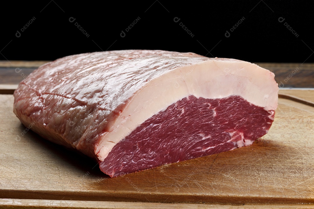 Peça de picanha sobre tábua de madeira