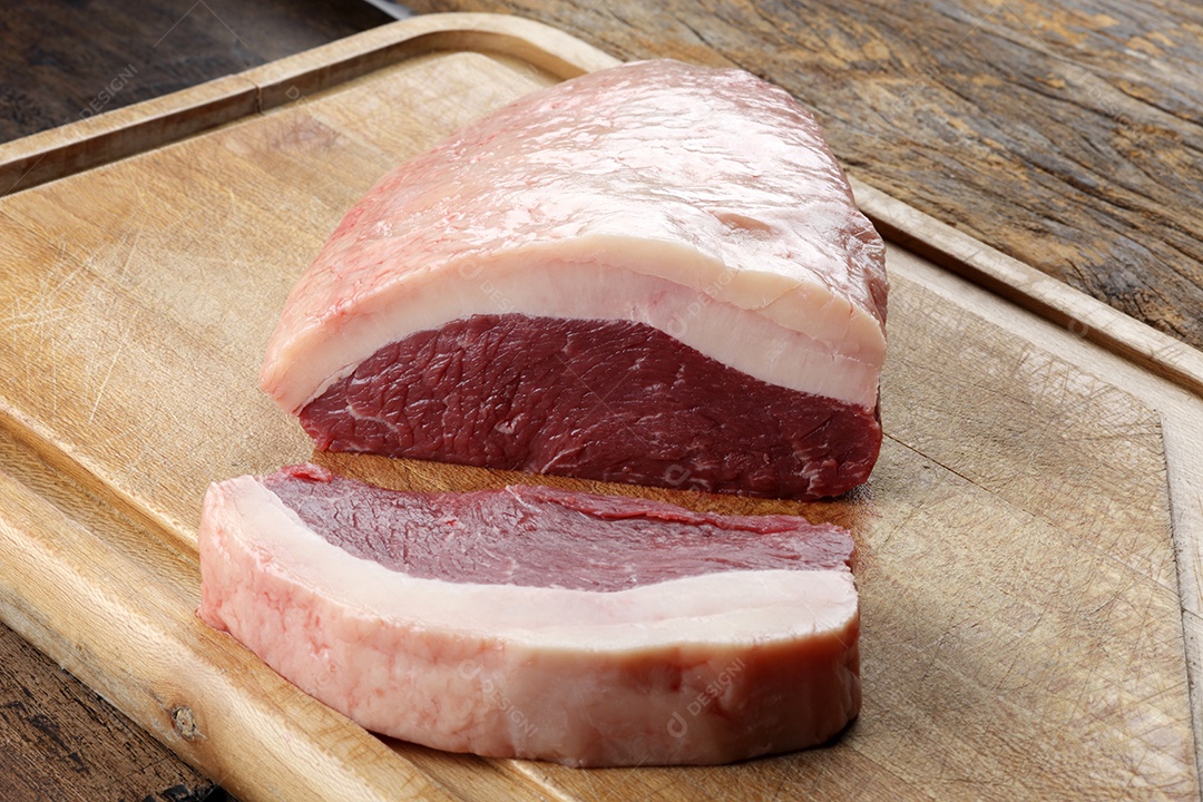 Peça de picanha sobre tábua de madeira