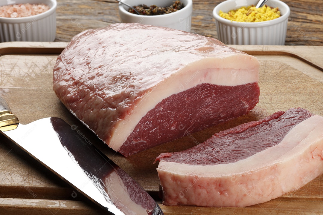 Peça de carne crua sobre tábua de madeira