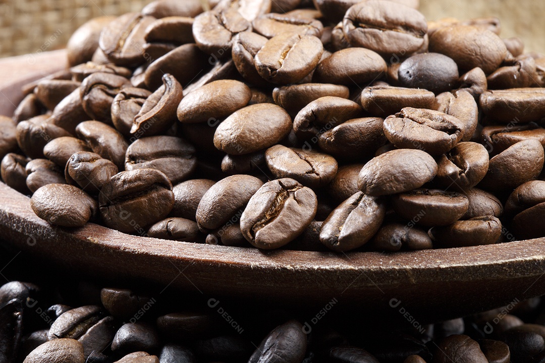 Tigela com grãos de café sobre fundo de mesa de madeira