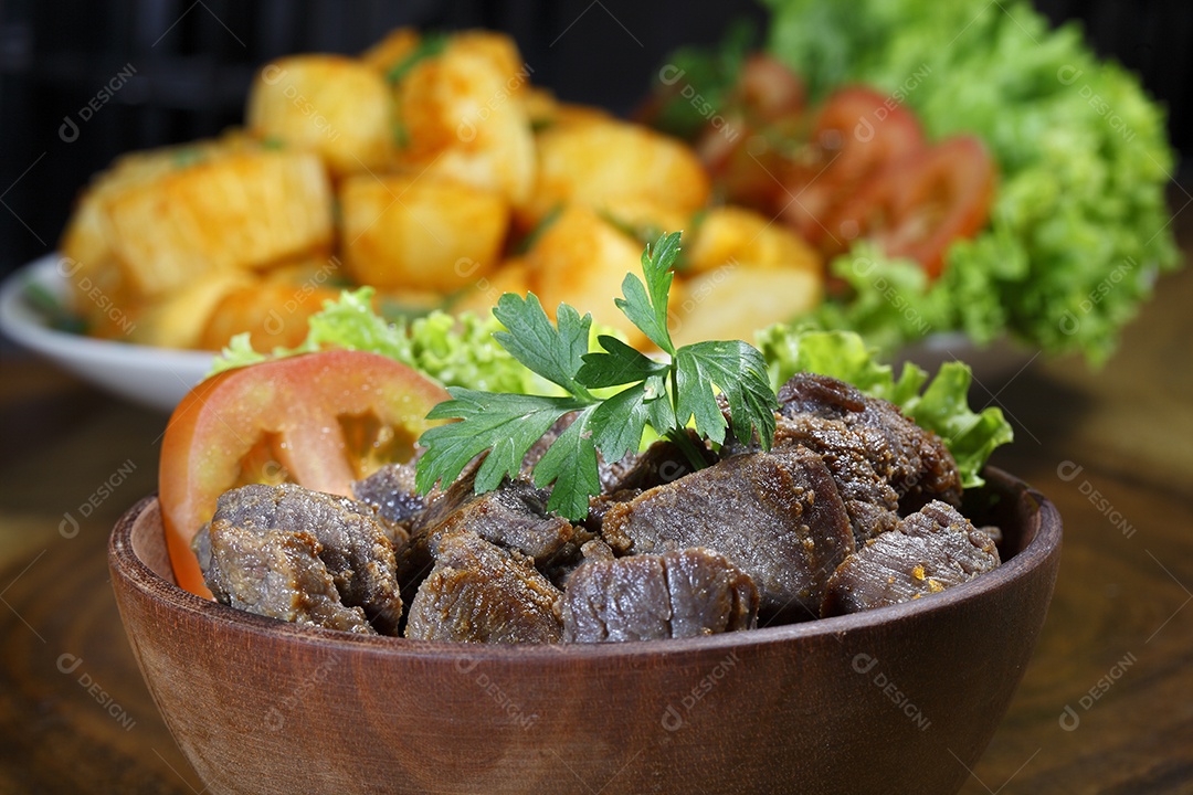 Carne frita com salada em uma mesa de madeira