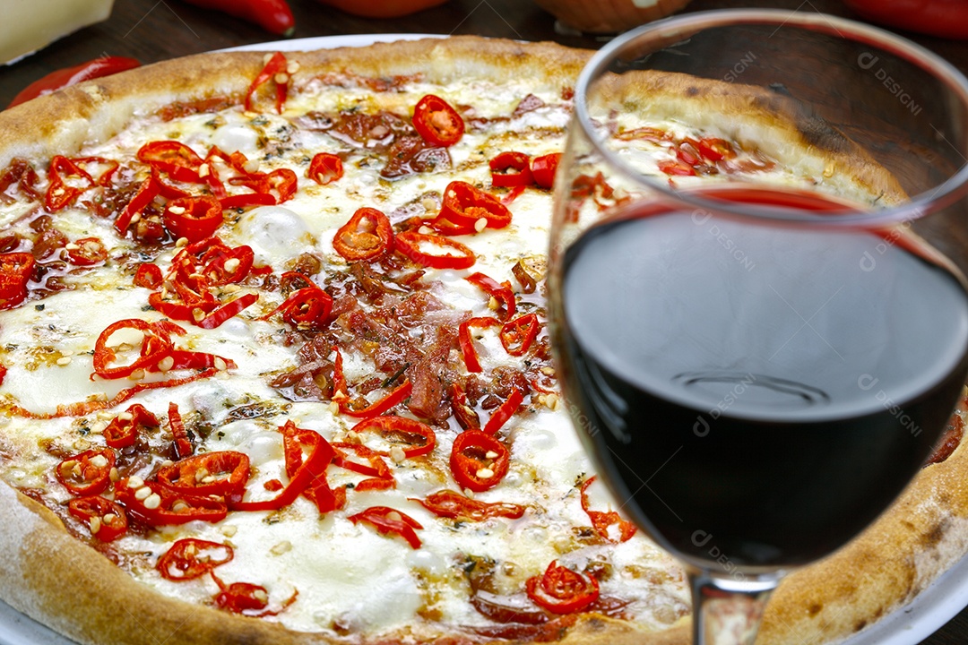 pizza de queijo com cortes de pimenta e taça de vinho