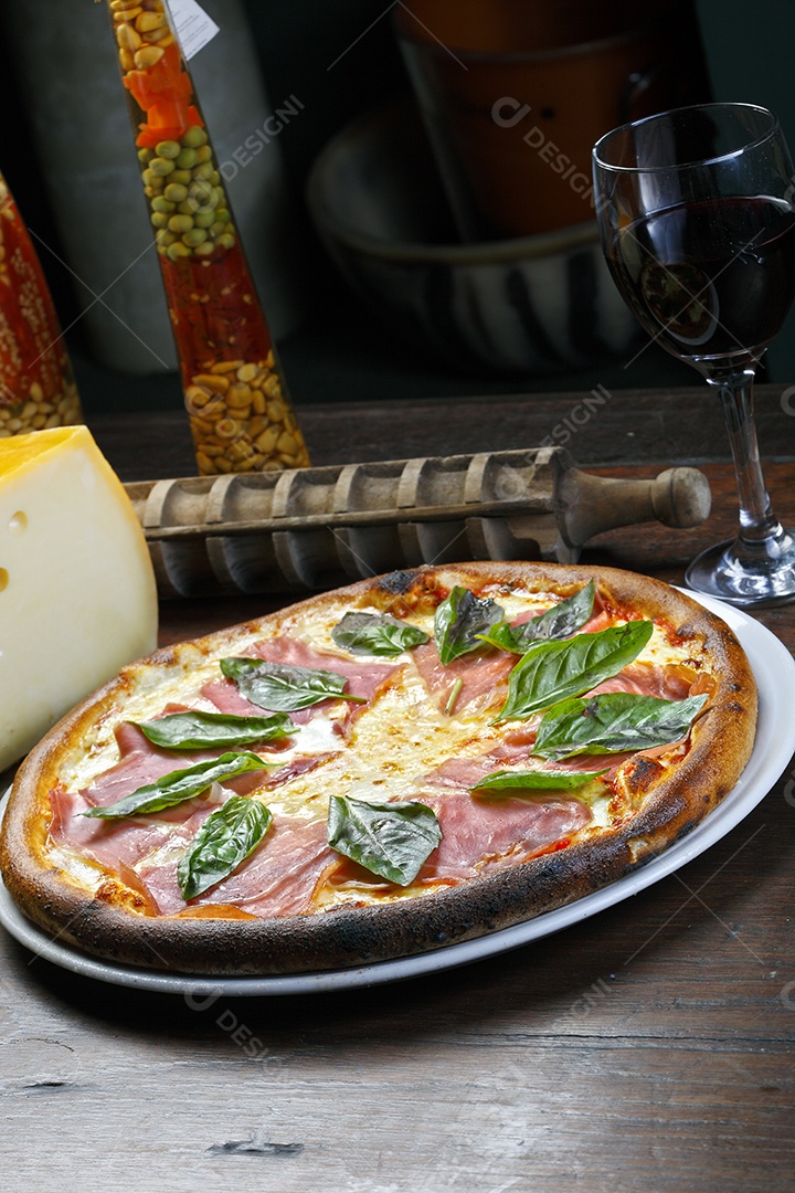 Pizza de presunto com manjericão e taça de vinho