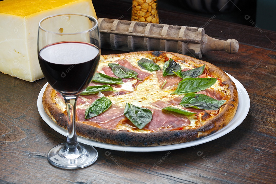 Pizza de presunto parma com folhas e taça de vinho