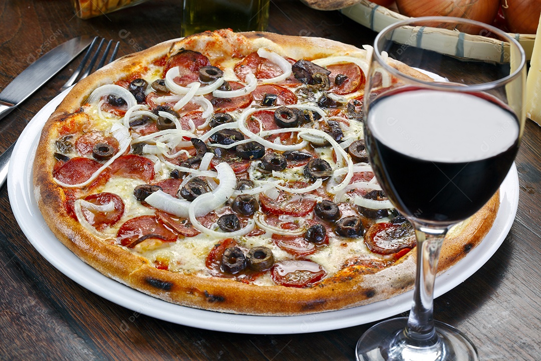Pizza de pepperoni sobre tábua de madeira com taça de vinho