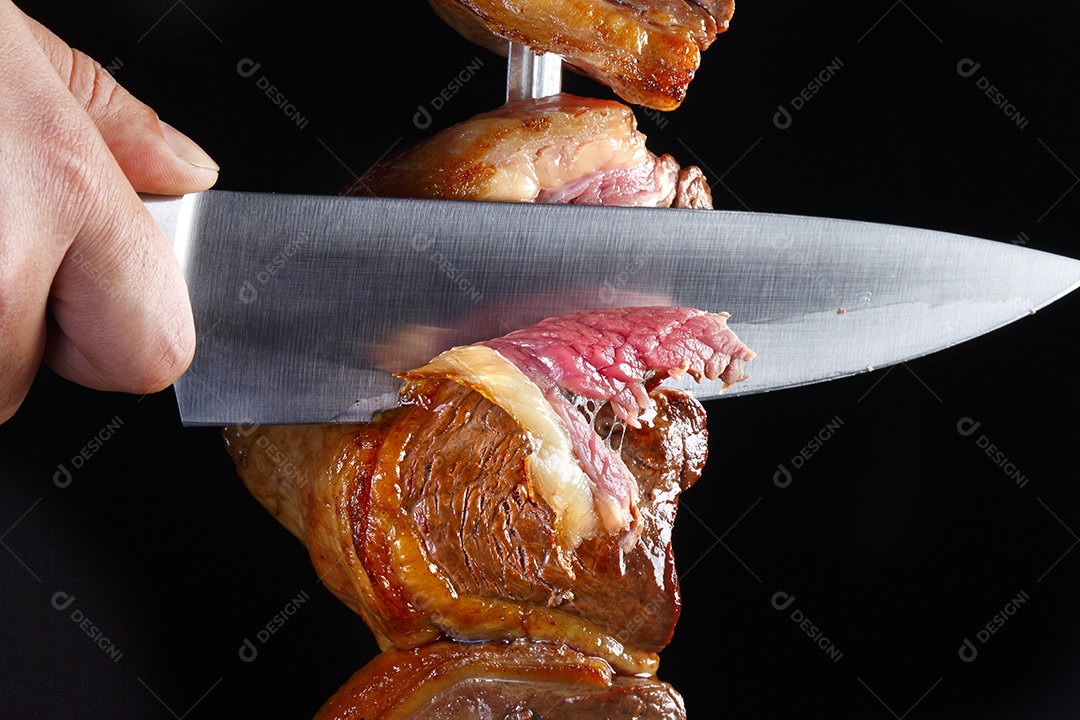 Espeto de picanha mal passado com mão cortando
